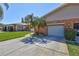 Charming exterior of home featuring a well-maintained lawn, landscaping, and a paved driveway at 3210 Mcmath Dr, Palm Harbor, FL 34684