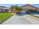 Charming exterior of home featuring a well-maintained lawn, landscaping, and a paved driveway at 3210 Mcmath Dr, Palm Harbor, FL 34684