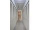Hallway featuring a wall of storage closets and leading to a bathroom at 3210 Mcmath Dr, Palm Harbor, FL 34684