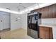 Kitchen with black refrigerator and brown cabinets, offering ample storage space and a view to another room at 3210 Mcmath Dr, Palm Harbor, FL 34684
