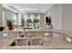 Modern kitchen featuring granite countertops, stainless steel sink, and an open view to the lush backyard at 4614 Alexandria Ct, Palmetto, FL 34221