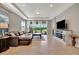 Bright living room with natural light has a comfortable leather couch, tile flooring, and neutral walls at 4614 Alexandria Ct, Palmetto, FL 34221