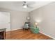 Neutral bedroom featuring wood floors, ceiling fan, and gray cushioned chair and side table at 5141 Sunnydale W Cir, Sarasota, FL 34233