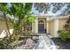 Beautiful home entrance featuring an elegant doorway framed by lush tropical landscaping at 5141 Sunnydale W Cir, Sarasota, FL 34233