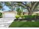 Charming home exterior with a well-maintained lawn, mature trees, and a two-car garage at 5141 Sunnydale W Cir, Sarasota, FL 34233