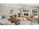 Open-concept living room featuring a fireplace, ceiling fan, and abundant natural light at 5141 Sunnydale W Cir, Sarasota, FL 34233