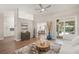 Open-concept living room with hardwood floors, a ceiling fan, and seamless flow to the kitchen at 5141 Sunnydale W Cir, Sarasota, FL 34233