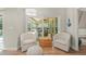 Cozy sitting area with comfortable armchairs and sliding glass doors to outdoor living space at 5141 Sunnydale W Cir, Sarasota, FL 34233