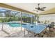 Bright patio featuring a ping pong table, a pool, and a ceiling fan at 5141 Sunnydale W Cir, Sarasota, FL 34233