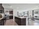 Modern kitchen with a large island and bar seating, seamlessly flowing into the adjacent living area at 5230 Salt Marsh Rd, Wimauma, FL 33598