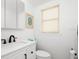 Bathroom featuring a pristine white vanity, toilet, and a window with natural light at 6140 Midnight Pass Rd, Sarasota, FL 34242