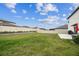 Spacious backyard featuring lush green grass and a modern fence, providing privacy and a tranquil outdoor space at 6241 Spider Lily Way, New Port Richey, FL 34653