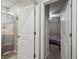 Clean bathroom with a shower and a view into an adjacent bedroom through an open door at 6241 Spider Lily Way, New Port Richey, FL 34653