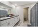Bathroom features a double vanity with granite countertop, white cabinetry, and gray decorative curtain at 6241 Spider Lily Way, New Port Richey, FL 34653