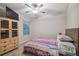 Cozy bedroom with a colorful blanket, a ceiling fan, and a window providing natural light at 6241 Spider Lily Way, New Port Richey, FL 34653