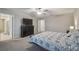 Neutral bedroom featuring a ceiling fan, dark wood dresser with a TV, and ensuite bathroom at 6241 Spider Lily Way, New Port Richey, FL 34653