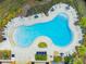 A high angle shot showing a modern community pool surrounded by lounge chairs and landscaping at 6241 Spider Lily Way, New Port Richey, FL 34653