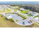 Aerial shot of a community featuring a parking area, pool, recreation center, and green spaces at 6241 Spider Lily Way, New Port Richey, FL 34653