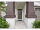 Inviting front entrance with decorative columns, security features, and landscaped surroundings, providing a warm welcome at 6241 Spider Lily Way, New Port Richey, FL 34653