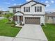 Charming two-story home featuring a well-maintained lawn, a two-car garage, and classic architectural details at 6241 Spider Lily Way, New Port Richey, FL 34653