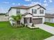 Well-manicured front yard with lush landscaping complements the home's exterior, enhancing curb appeal at 6241 Spider Lily Way, New Port Richey, FL 34653