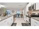 Open kitchen design with white cabinets, stainless steel appliances, and a seamless flow into the dining area at 6241 Spider Lily Way, New Port Richey, FL 34653