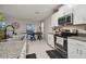 Bright kitchen featuring stainless appliances, granite countertops, and an open view into the dining room and backyard at 6241 Spider Lily Way, New Port Richey, FL 34653