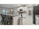 Modern kitchen featuring a granite countertop island with barstool seating, stainless steel appliances, and a walk-in pantry at 6241 Spider Lily Way, New Port Richey, FL 34653