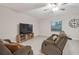 Cozy living room featuring tile floors, a ceiling fan and comfortable reclining sofas with lots of natural light at 6241 Spider Lily Way, New Port Richey, FL 34653
