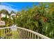 View from the balcony, showing the tropical landscaping and a peek of the water and sky at 6345 Vista Verde E Dr, Gulfport, FL 33707