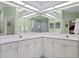 Clean bathroom with a double sink vanity, white cabinets, and a large mirror for morning routines at 6345 Vista Verde E Dr, Gulfport, FL 33707