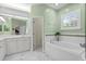 Well-lit bathroom with a soaking tub, white tiling, and a large window for natural light is serene at 6345 Vista Verde E Dr, Gulfport, FL 33707