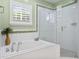 Spa-like bathroom with a soaking tub, a glass-enclosed shower, and large window for light is elegant at 6345 Vista Verde E Dr, Gulfport, FL 33707