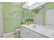 Bathroom featuring white cabinets and vanity, a plant, and fish decor on the light green colored walls at 6345 Vista Verde E Dr, Gulfport, FL 33707