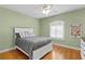 Bedroom featuring hardwood floors, a ceiling fan, and a white bed frame with light green colored walls at 6345 Vista Verde E Dr, Gulfport, FL 33707