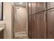 Bathroom featuring a walk-in shower with glass doors and custom wood storage at 7069 Key Haven Rd # 205, Seminole, FL 33777
