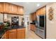 Bright kitchen with stainless steel refrigerator, wooden cabinets and granite countertops at 7069 Key Haven Rd # 205, Seminole, FL 33777