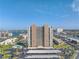 Stunning aerial view of the condo building showcasing its waterfront location, parking area, pool, and surrounding cityscape under a blue sky at 7300 Sun Island S Dr # 802, South Pasadena, FL 33707