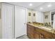 Bathroom with wood cabinets, granite counters, vanity mirror and double door closet at 7300 Sun Island S Dr # 802, South Pasadena, FL 33707