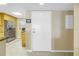 Hallway view with a white front door, stainless steel refrigerator and kitchen at 7300 Sun Island S Dr # 802, South Pasadena, FL 33707