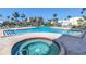 Community swimming pool and hot tub offers relaxation with lounge chairs, and palm trees at 7300 Sun Island S Dr # 802, South Pasadena, FL 33707