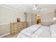 Bright main bedroom with a ceiling fan, carpet floors, and a doorway leading to the attached main bathroom at 7631 Citrus Blossom Dr, Land O Lakes, FL 34637