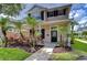 Charming two-story home featuring a well-manicured lawn, tropical landscaping, and a welcoming front porch at 8907 Ashford Gables, Tampa, FL 33626