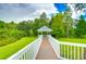 Scenic gazebo accessible via wooden bridge set amid lush greenery with water view providing a tranquil and picturesque setting at 8907 Ashford Gables, Tampa, FL 33626