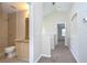 Hallway with carpet leads to bathroom with tiled shower and granite vanity at 8907 Ashford Gables, Tampa, FL 33626