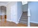 Hallway with hardwood floors, carpeted stairs, white trim, and arched doorway leading to another room at 8907 Ashford Gables, Tampa, FL 33626