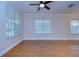 Bright living room with hardwood floors, multiple windows, crown molding, and a ceiling fan at 8907 Ashford Gables, Tampa, FL 33626