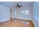 Bright living room featuring hardwood floors, crown molding, ceiling fan, a door and large windows at 8907 Ashford Gables, Tampa, FL 33626