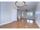 Open-concept living area with hardwood floors, chandelier, stairway, and large windows with natural light at 8907 Ashford Gables, Tampa, FL 33626