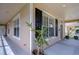 Inviting covered porch with neutral tones, decorative black shutters and large windows at 8907 Ashford Gables, Tampa, FL 33626